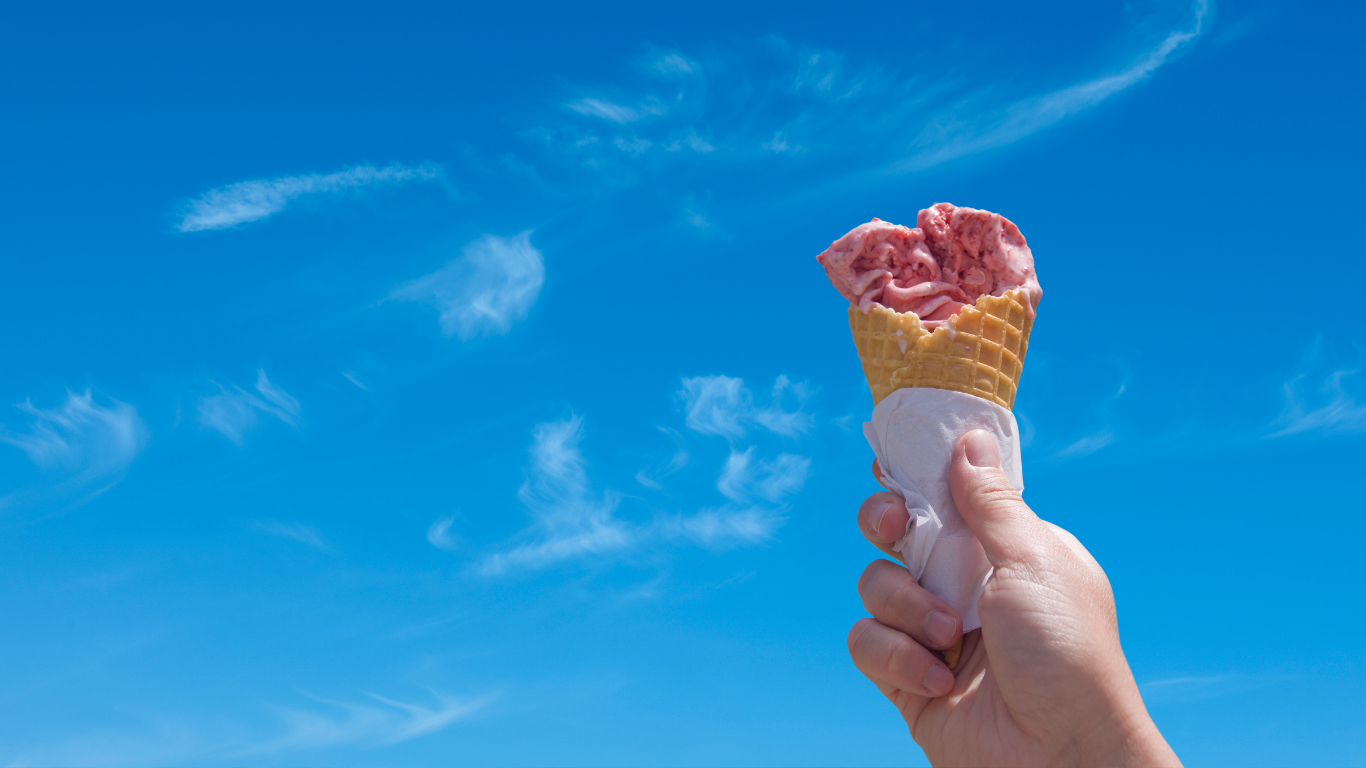 ice cream cone held up to a blue sky